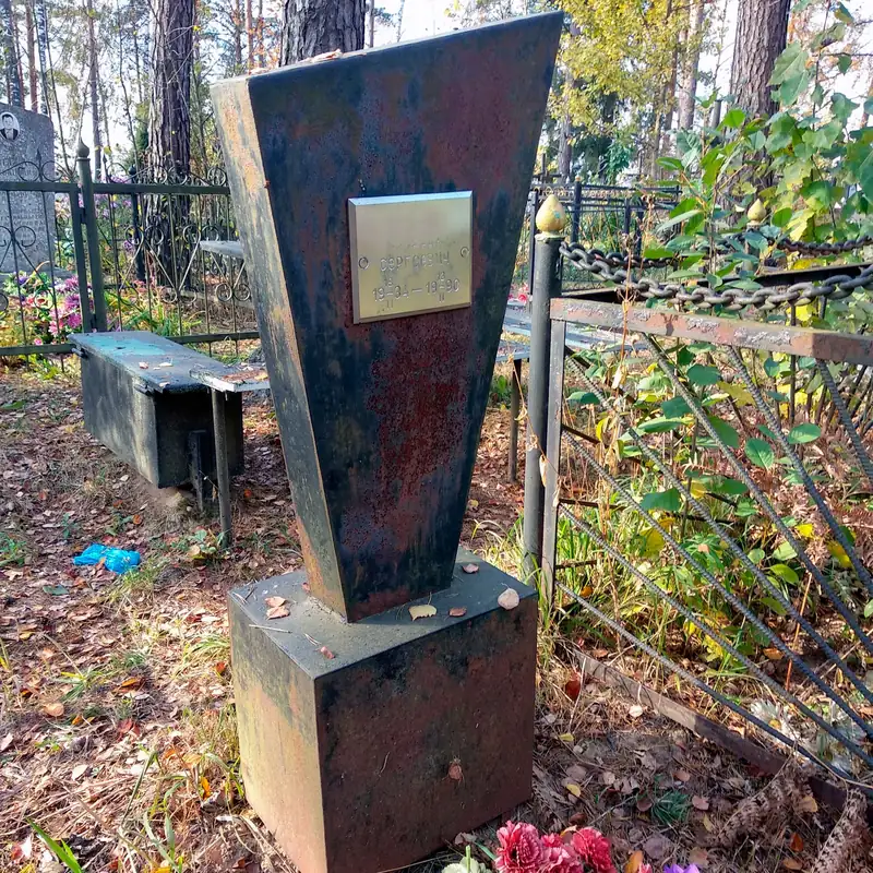 Металлический памятник на тумбе, покрытый ржавчиной, с латунной табличкой